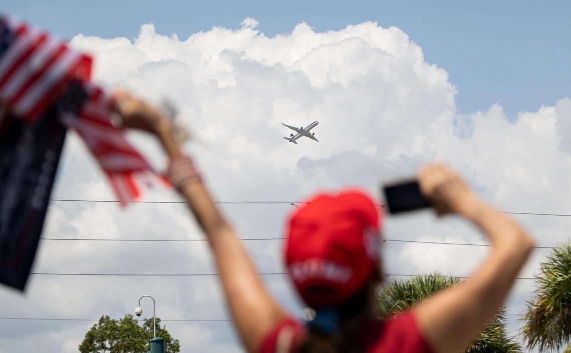 A supporter of former President Donald Trump waves as he departs from Palm Beach International Airport on Monday, April 3, 2023, in West Palm Beach, Florida.