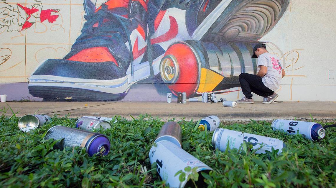 Zach Curtis from Detroit paints his mural at Madison Middle School in Miami. A group of artists from around the world came together to paint murals at the school during Miami Art Week.