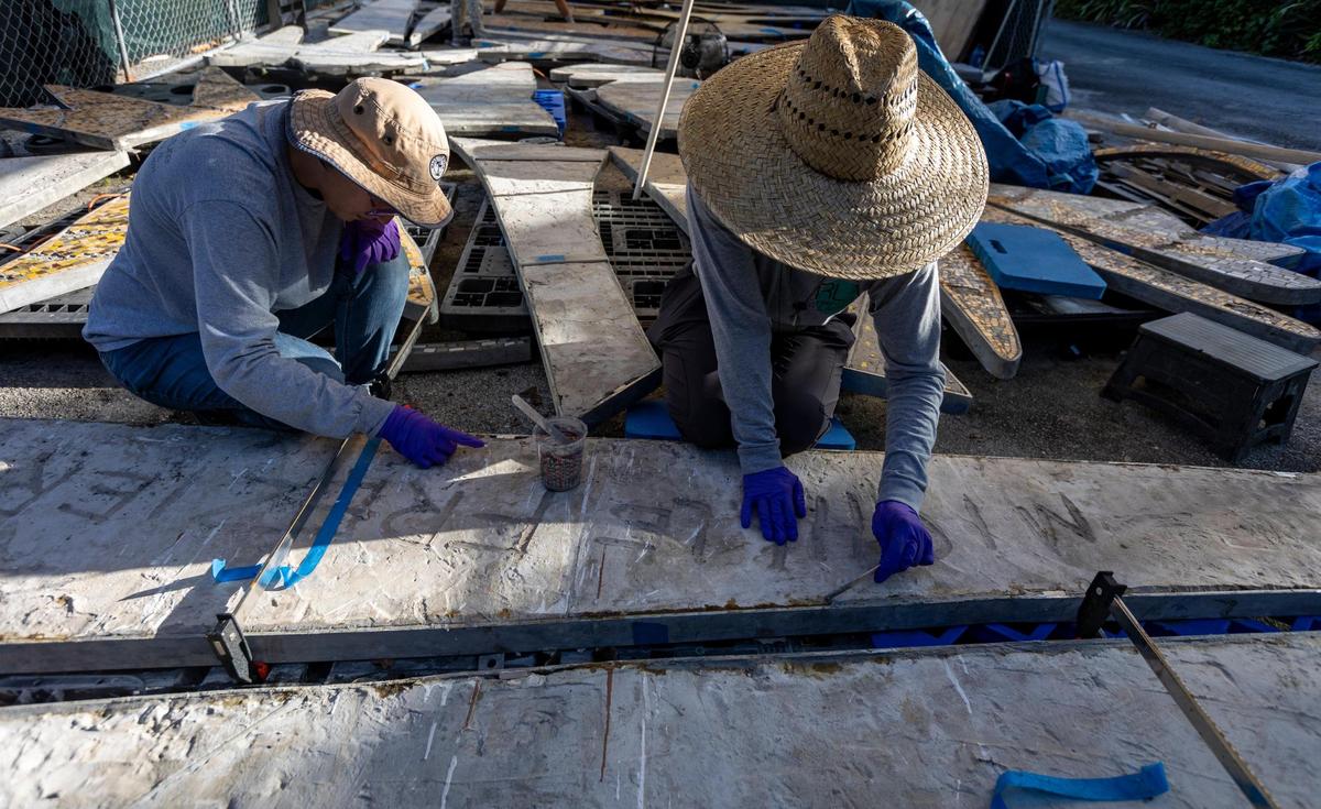 Technicians Sammi Sassi, left, and Emily Rojas of RLA Conservation work on the back of a section of a 1950s mosaic mural depicting the Greek god Apollo that is undergoing restoration at the Bakehouse Art Complex in Wynwood. The Miami Beach mural, removed and saved by preservationists in 2015 from impending destruction, will be reinstalled at a new South Beach fire station.