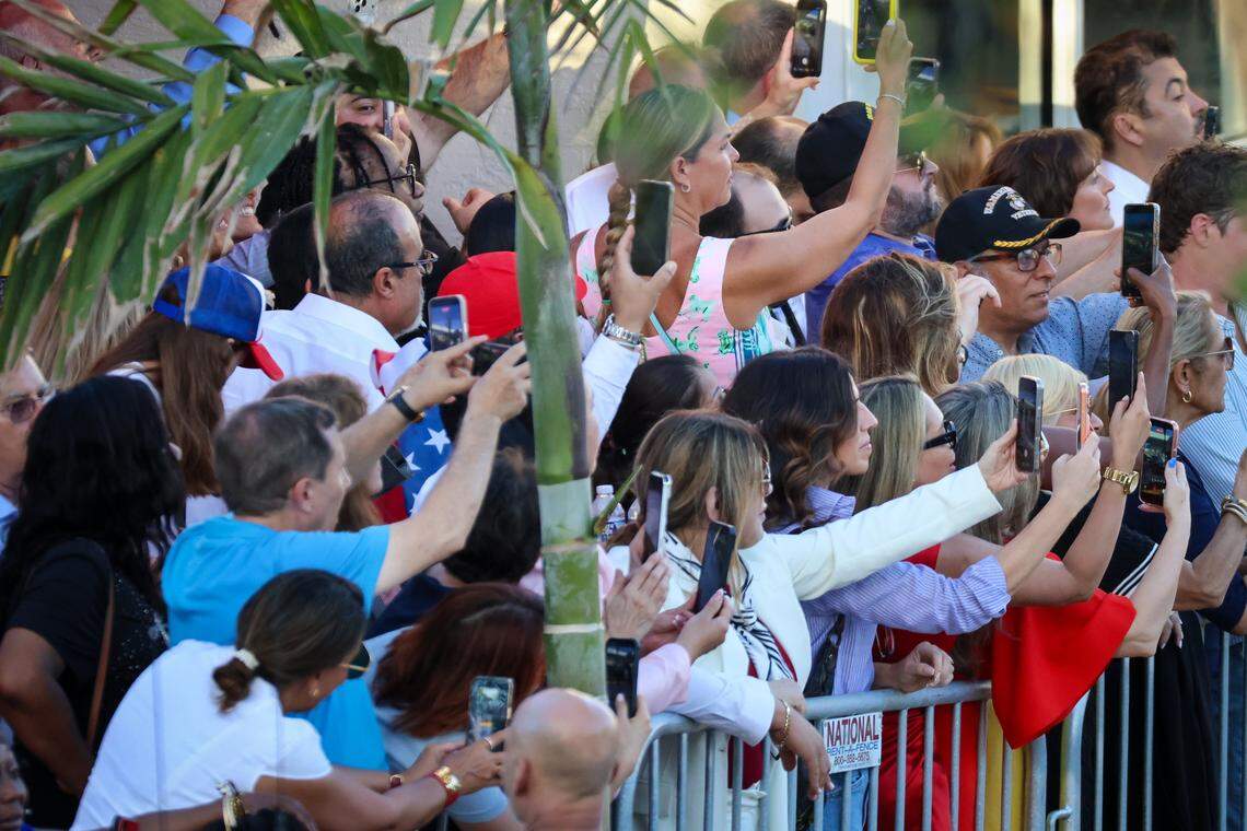 A small group of invitees takes cellphone pictures and video of President Donald Trump as upon his arrival during a visit to El Arepazo, a Venezuelan community hub in Doral, for a brief four-minute stop, greeting Republican guests invited to the restaurant on Monday, March 9, 2026, in Doral, Florida.