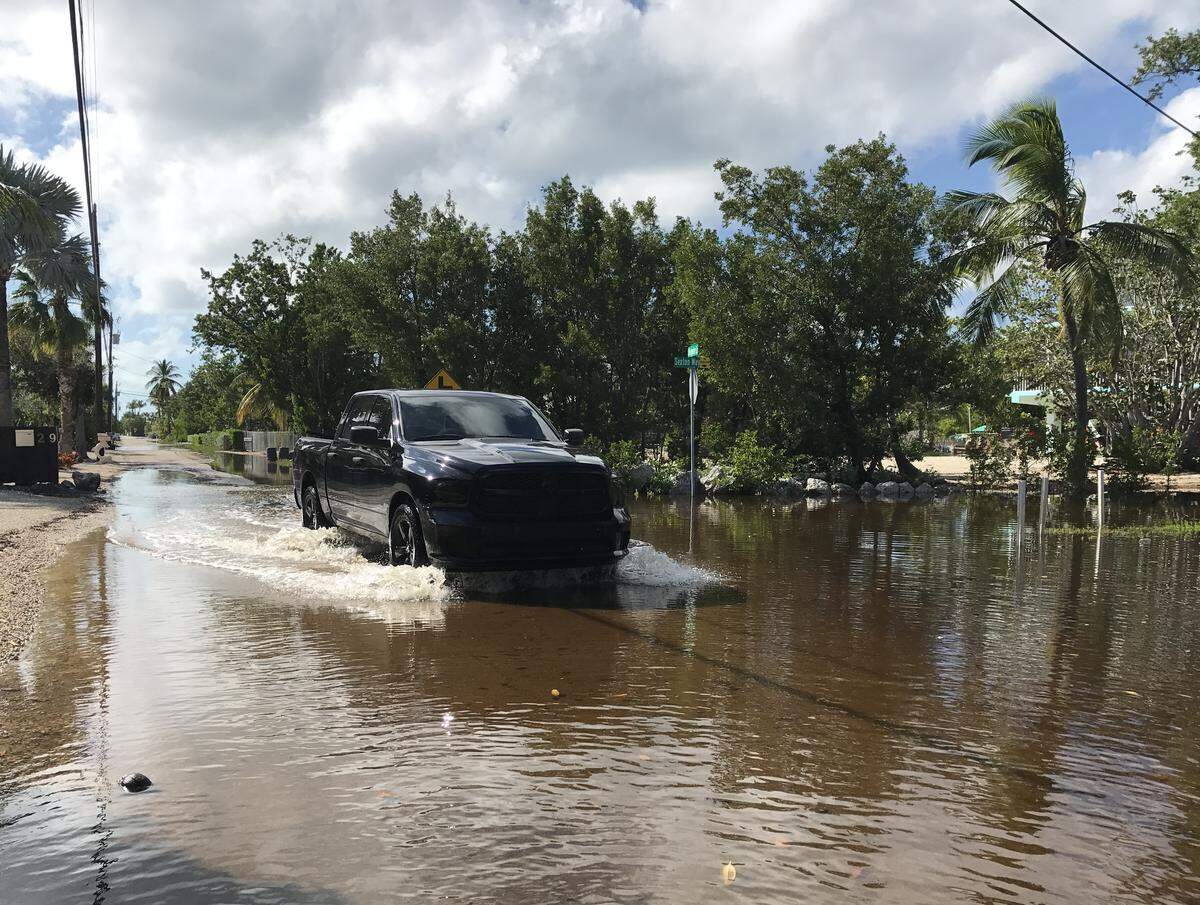 A pickup truck drives east on a flooded North Blackwater Lane in the Key Largo Stillwright Point subdivison Tuesday, Oct. 15, 2019. The waters began to ebb in December after more than 90 days of flooding.