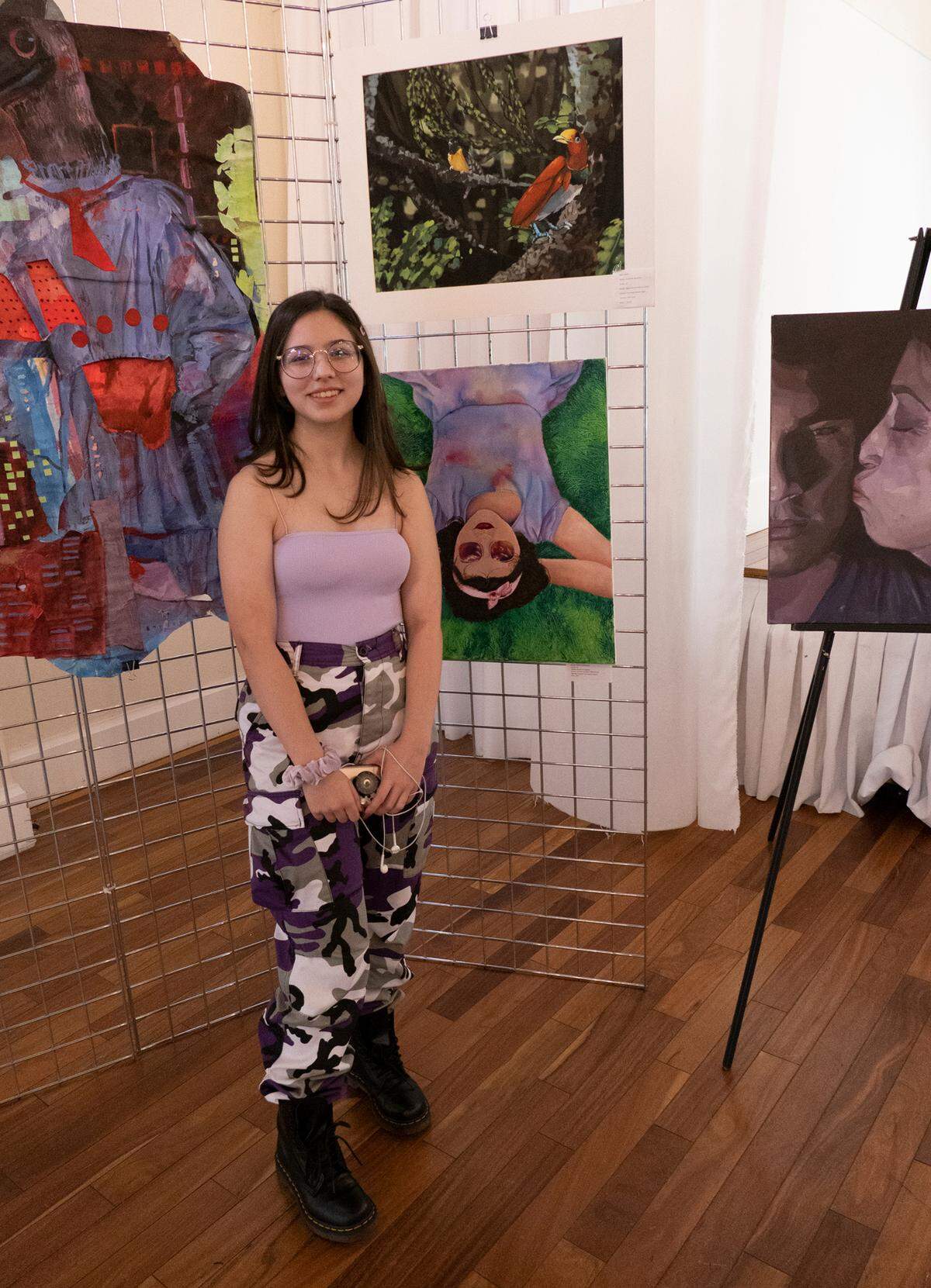 At the 2020 Young Artists’ Gallery, Hialeah Gardens High School senior Melanie Mederos stands in front of her artwork at top, titled ‘Hanging On.’ The free Woman’s Club of Coconut Grove event will be held outside March 13-14 with mask-wearing and social distancing protocols in place.