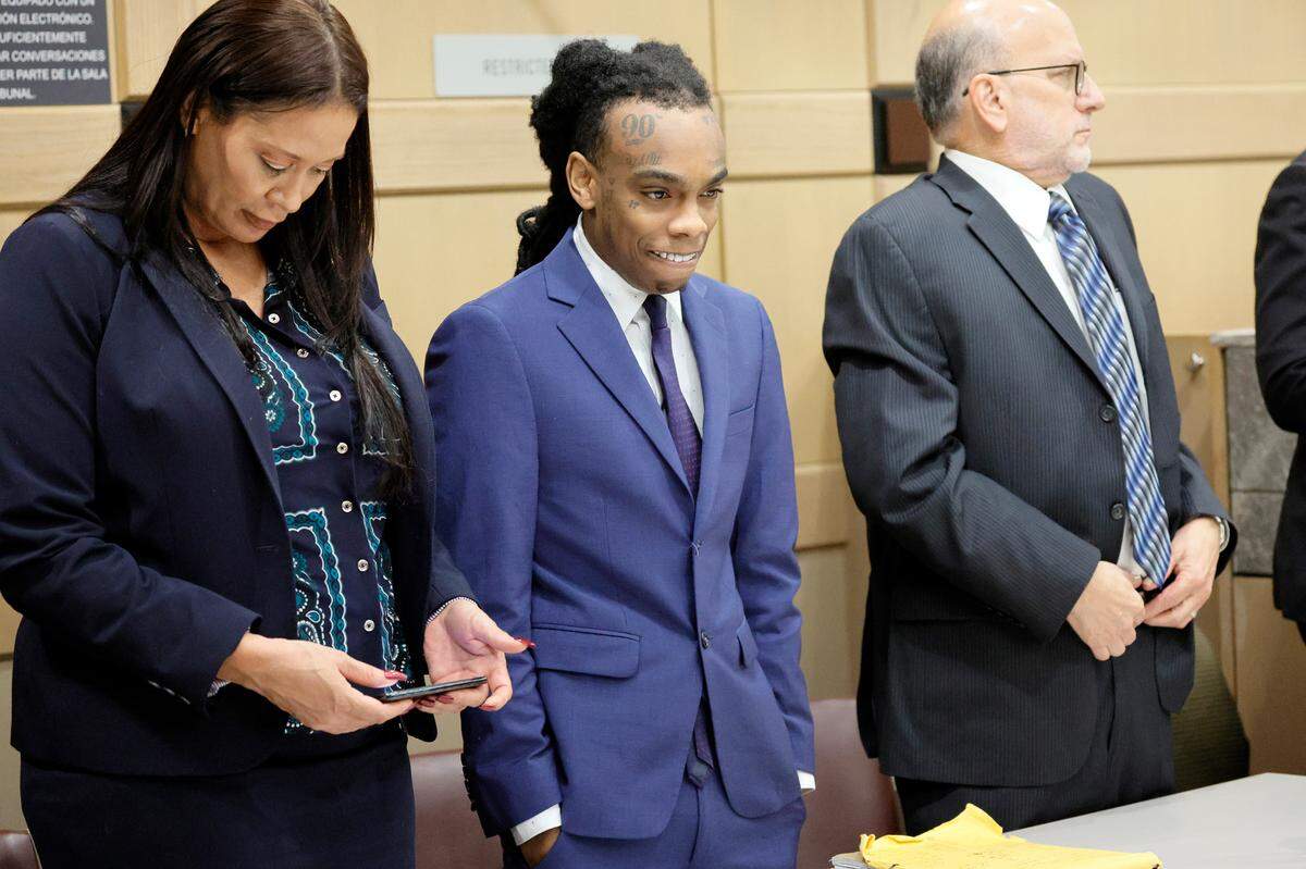 Jamell Demons, center, better known as rapper YNW Melly, stands with defense attorneys Raven Ramona Liberty and Stuart Adelstein as the jury enters the room to hear a witness’s testimony read back in his trial at the Broward County Courthouse in Fort Lauderdale on Friday, July 21, 2023. Demons, 22, is accused of killing two fellow rappers and conspiring to make it look like a drive-by shooting in October 2018. (Amy Beth Bennett / South Florida Sun Sentinel)