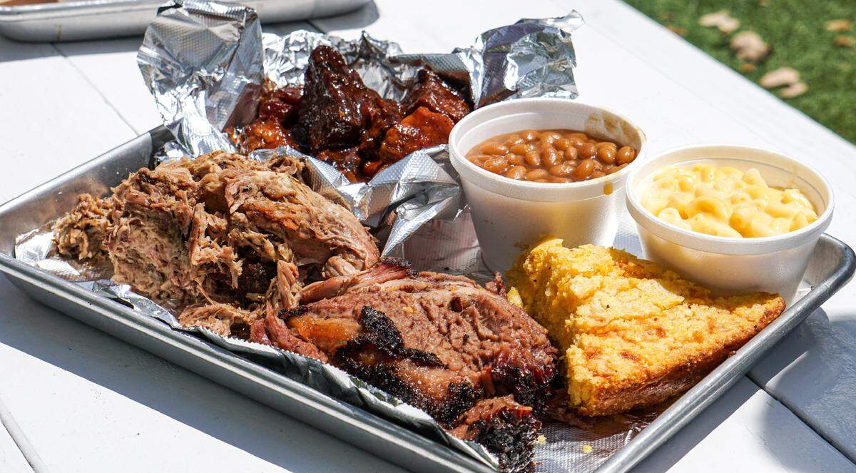 A platter of food at Apocalypse Barbecue in Wynwood could include this sampling of brisket, pulled pork, pork belly “burnt ends,” cornbread, baked beans and mac and cheese.