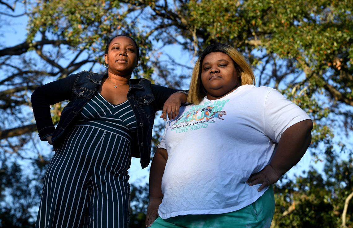 Sisters Maya and Malekia McKinney stand in the setting sun on the property where they grew up in St. Petersburg. The home is no longer there. The city bought the property after it was foreclosed upon for unpaid code enforcement fines.