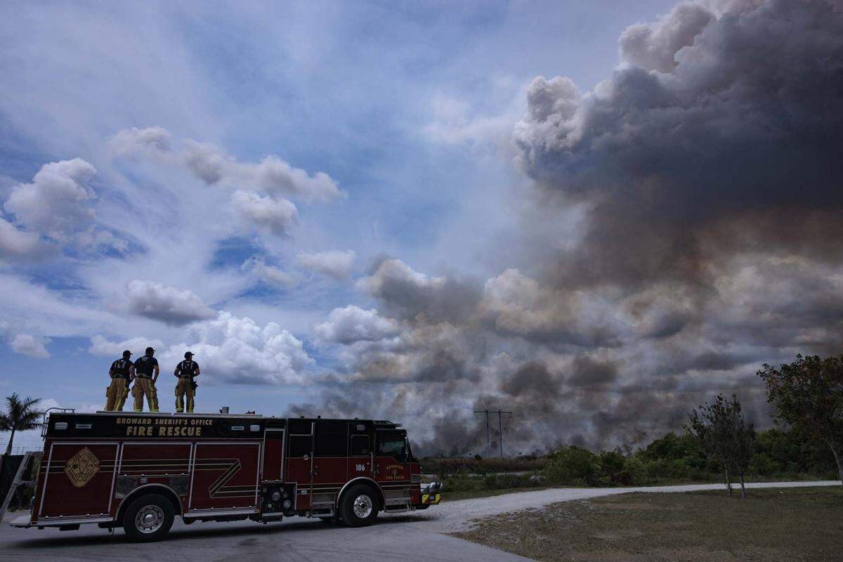 Broward Sheriffs Office Fire Rescue team monitors a wildfire burning west of Weston into the Everglades on Monday, May 11, 2026, seen from Everglades Holiday Park in Fort Lauderdale, Fla.