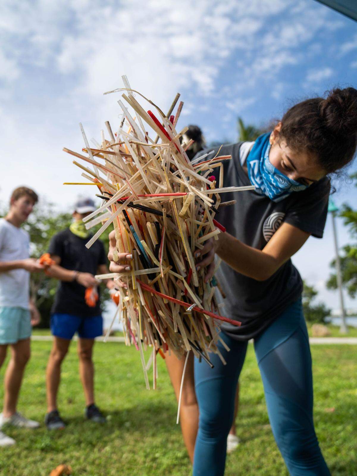 Sendit4thesea volunteer Brittney Silva holds up plastic straws recovered from cleanups around the Miami area.