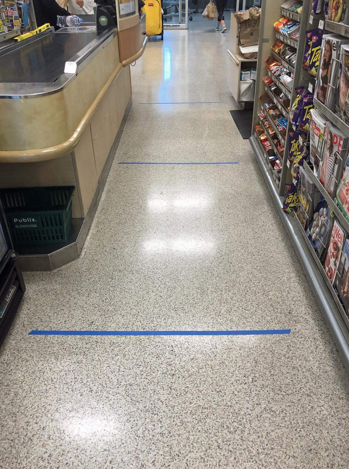 Blue tape on the floor of a Publix shows shoppers how far each person should be from the next.