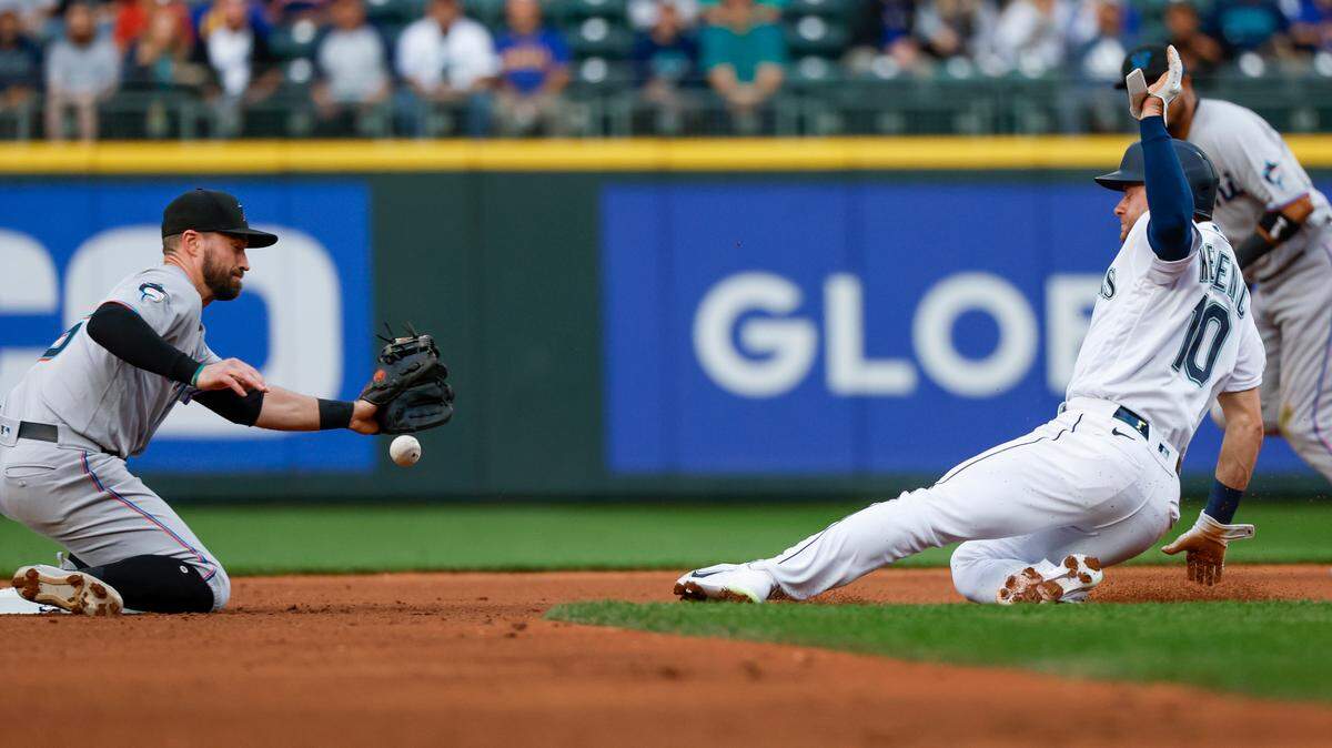 Jun 13, 2023; Seattle, Washington, USA; Seattle Mariners left fielder Jarred Kelenic (10) steals second base as Miami Marlins shortstop Jon Berti (5) attempts to field a throw during the fourth inning at T-Mobile Park. Mandatory Credit: Joe Nicholson-USA TODAY Sports