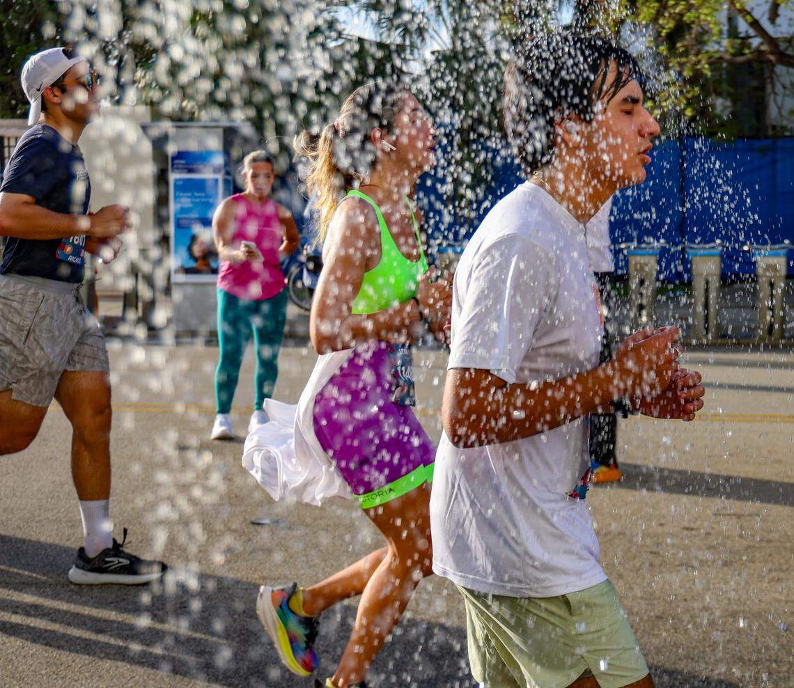 Runners cool off after exiting the Venetian Causeway at the 11-Mile marker during the Life Time Miami Marathon on Sunday, January 28, 2024 in Miami, Florida