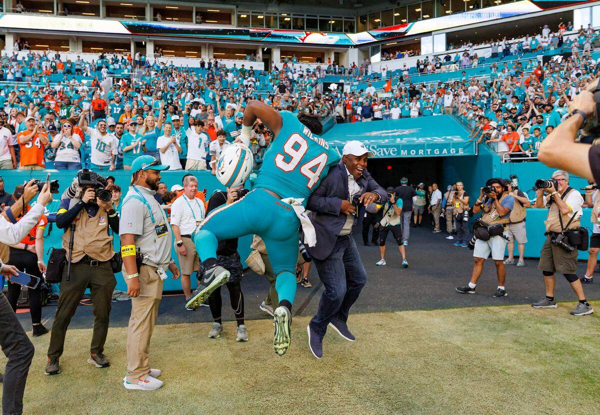 Miami Dolphins general manager Chris Grier and Dolphins defensive tackle Christian Wilkins (94) celebrates their 11-6 win over the New York Jets during an NFL football game at Hard Rock Stadium on Sunday, January 8, 2023 in Miami Gardens, Florida.