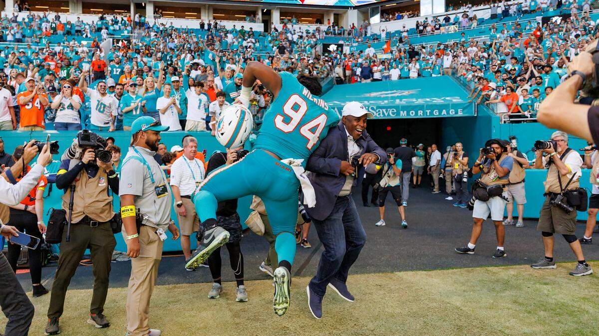 Miami Dolphins general manager Chris Grier and Dolphins defensive tackle Christian Wilkins (94) celebrates their 11-6 win over the New York Jets during an NFL football game at Hard Rock Stadium on Sunday, January 8, 2023 in Miami Gardens, Florida.