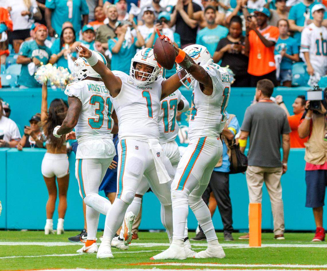 Miami Dolphins wide receiver Trent Sherfield (14) celebrates with teammate Dolphins quarterback Tua Tagovailoa (1) during second quarter of an NFL football game at Hard Rock Stadium on Sunday, November 13, 2022 in Miami Gardens, Florida.