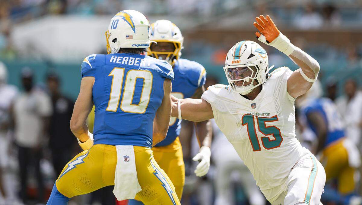 Miami Dolphins linebacker Jaelan Phillips (15) tries to sack Los Angeles Chargers quarterback Justin Herbert (10) in the first half of their NFL game at Hard Rock Stadium on Sunday, Oct. 12, 2025, in Miami Gardens, Fla.