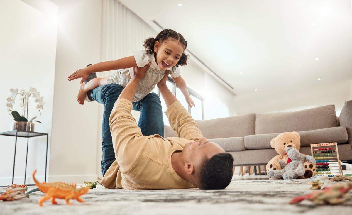 father daughter play airplane