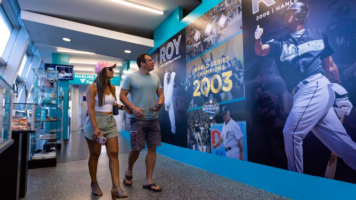 Jeff Campbell, 40, and Luana Fureando, 40, look at posters displayed in the Miami Marlins 30th Anniversary History Museum inside loanDepot Park on Wednesday, May 17, 2023.