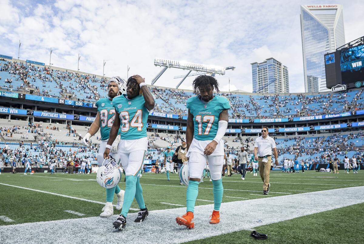 Miami Dolphins defensive tackle Zach Sieler (92), wide receiver Tahj Washington (84) and wide receiver Jaylen Waddle (17) makes their way back to the locker rooms after losing against the Carolina Panthers in their NFL game at the Bank of America Stadium on Sunday, Oct. 5, 2025, in Charlotte, N.C.
