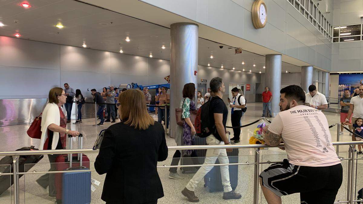 Danny Angelo, 23, waits with flowers for his girlfriend at Miami International Airport Friday, Aug. 16. A U.S. Customs and Border Protection computer outage caused long wait times for international travelers.
