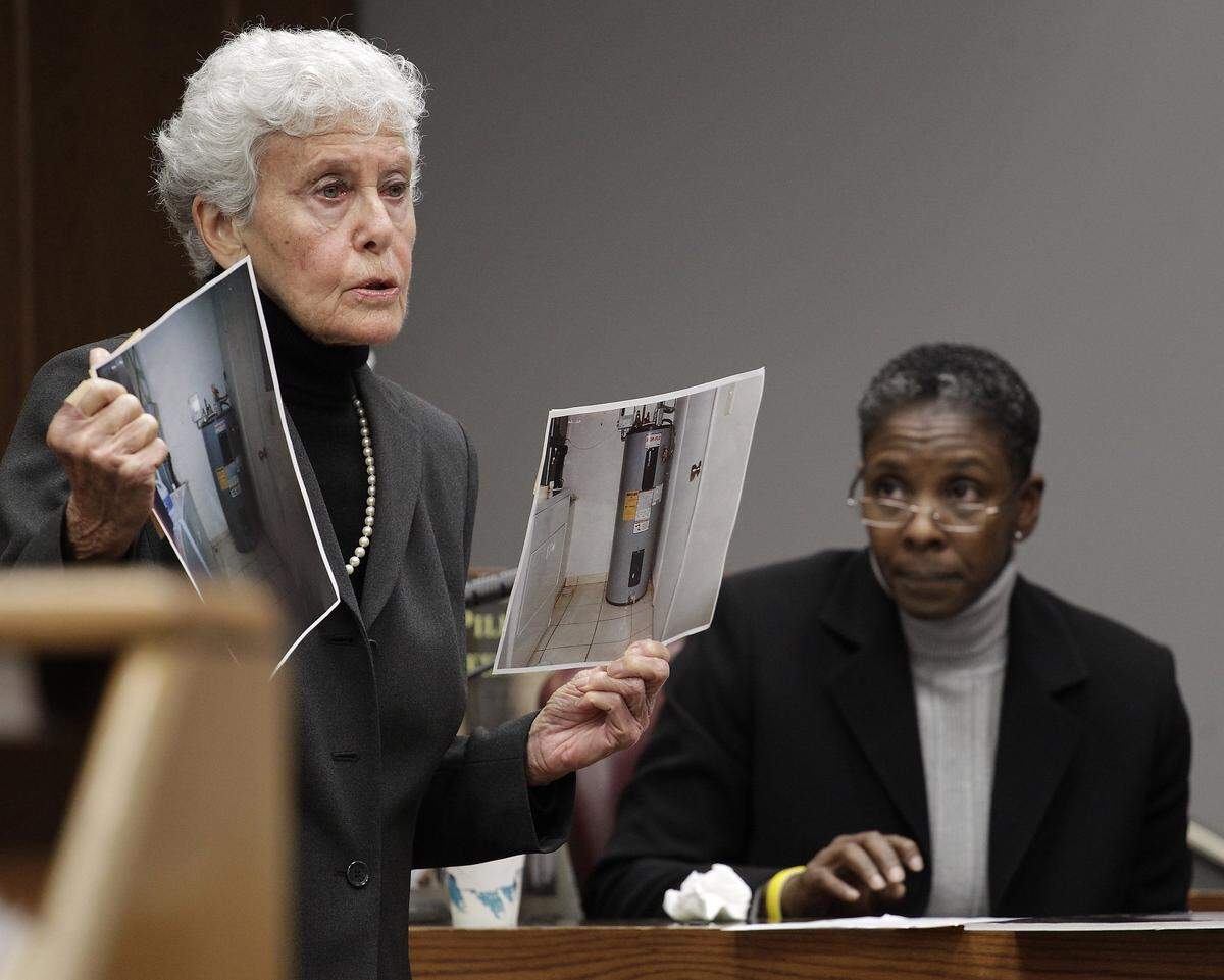 Prosecutor Sally Weintraub, left, shows the jury photos of the laundry room where Rilya Wilson was kept for days as Pamela Graham, right, testifies. Former domestic partner of Geralyn Graham, Pamela Graham (no blood relation) gave an emotional testimony at the Rilya Wilson trial in Miami on Dec. 17, 2012.