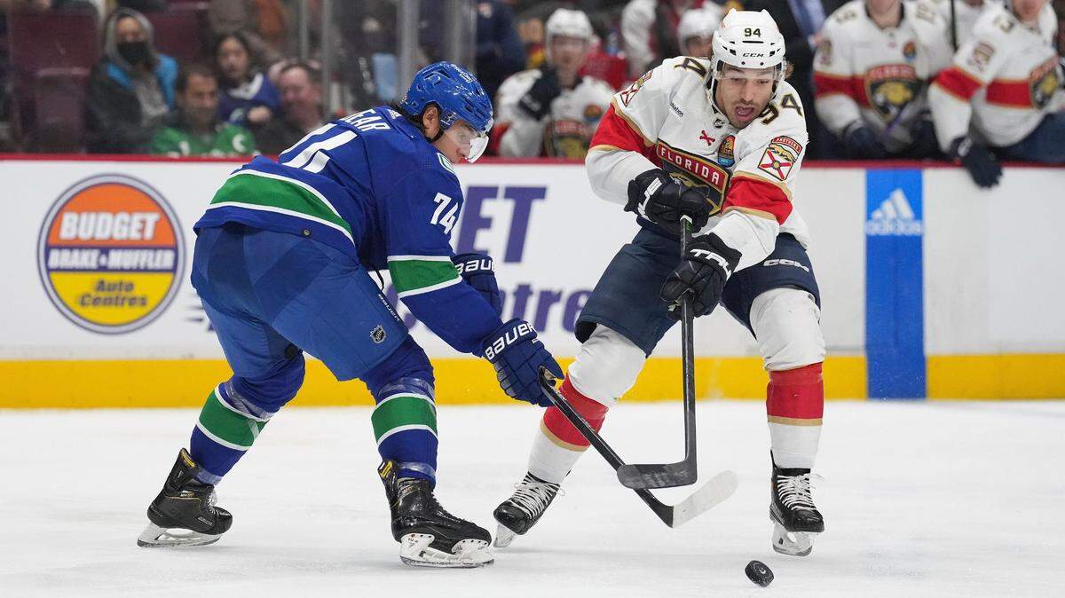 Vancouver Canucks’ Ethan Bear, left, and Florida Panthers’ Ryan Lomberg vie for the puck during the second period of an NHL hockey game Thursday, Dec. 1, 2022, in Vancouver, British Columbia.