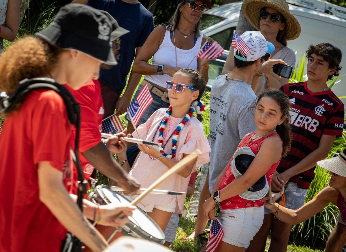 Maria Saez ,10, center, watches the marching band during the Fourth of July parade along Crandon Boulevard in Key Biscayne.