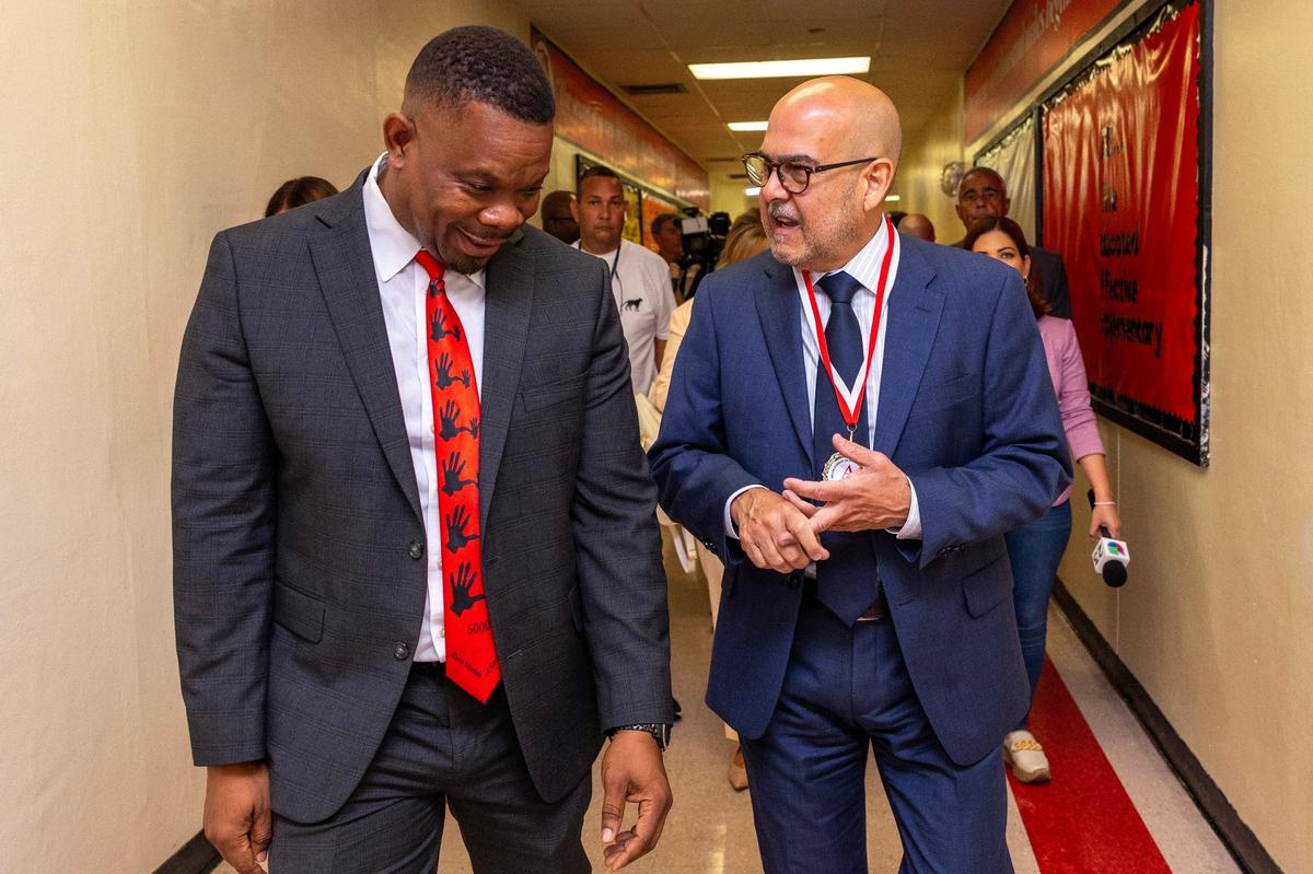 Superintendent of Miami-Dade County Public Schools Jose L. Dotres, right, speaks with Principal James Dominique, left, during the first day of school at Miami Edison High.