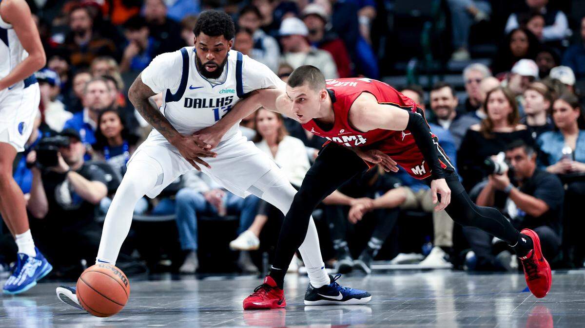 Miami Heat guard Tyler Herro (14) and Dallas Mavericks forward Naji Marshall (13) go for a loose ball during the first half at American Airlines Center.