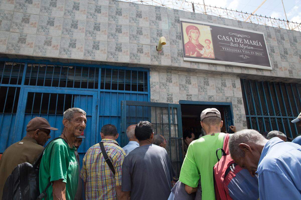 Hungry people line up outside Casa de Maria for lunch. For many, this will be their only meal of the day.