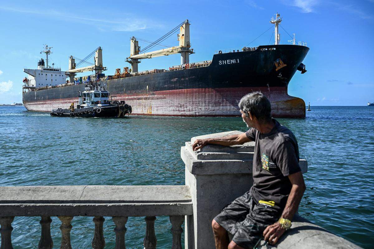 A man looks at the bulk carrier Shenli, sailing under the flag of Panama, in Puerto Cabello, Venezuela, on January 22, 2026. (Photo by Ronaldo SCHEMIDT / AFP via Getty Images)