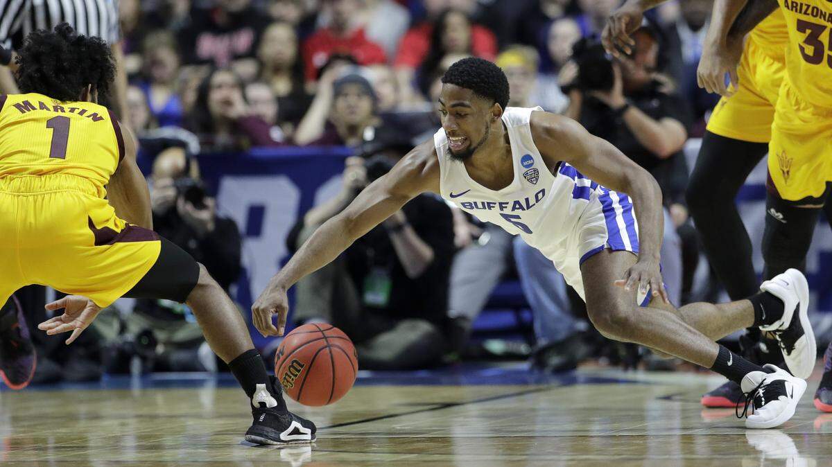 Buffalo’s CJ Massinburg (5) and Arizona’s Devonaire Doutrive (1) chase a loose ball during the first half of a first round men’s college basketball game in the NCAA Tournament Friday, March 22, 2019, in Tulsa, Okla.