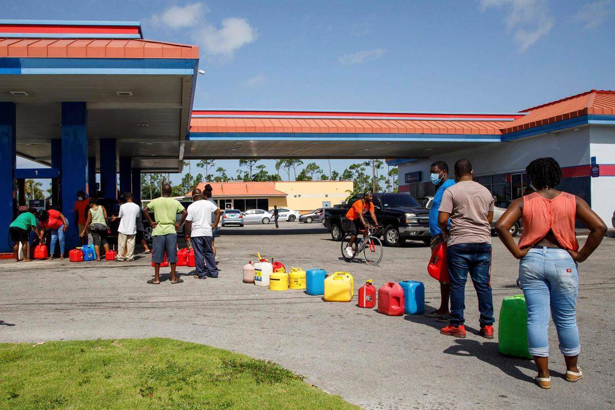 Residents wait in line to fill their containers with gasoline before the arrival of Hurricane Isaias in Freeport, Grand Bahama, Bahamas, Friday, July 31, 2020. (AP Photo/Tim Aylen)