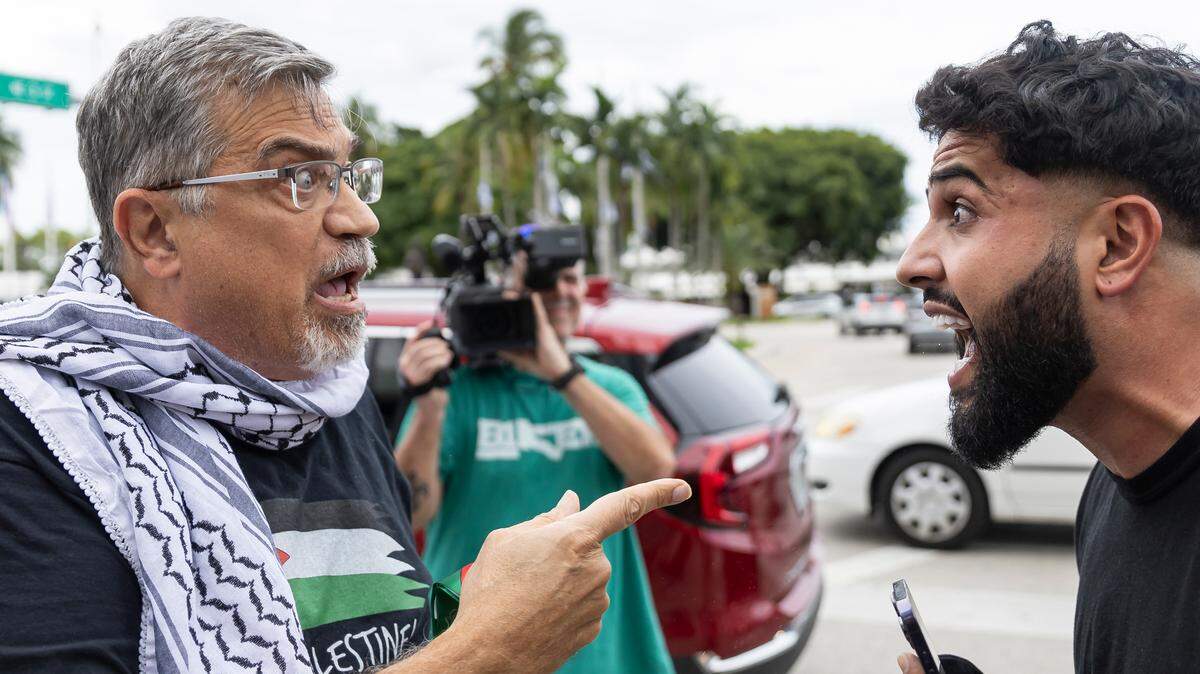 A pro-Palestinian activist, left, argues with a pro-Israel activist during a rally near the Torch of Friendship on Friday, Oct. 13, 2023, in downtown Miami, Fla.