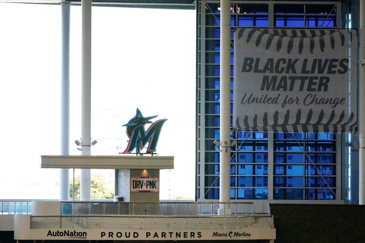 A Black Lives Matter banner hangs in the outfield before the start of a baseball game between the Miami Marlins and the Atlanta Braves, Friday, Aug. 14, 2020, in Miami. (AP Photo/Wilfredo Lee)