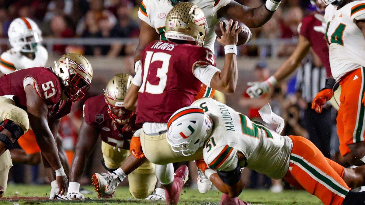Florida State Seminoles quarterback Jordan Travis (13) is sacked by Miami Hurricanes linebacker Francisco Mauigoa (51) in the fourth quarter at Doak Campbell Stadium in Tallahassee on Saturday, November 11, 2023.