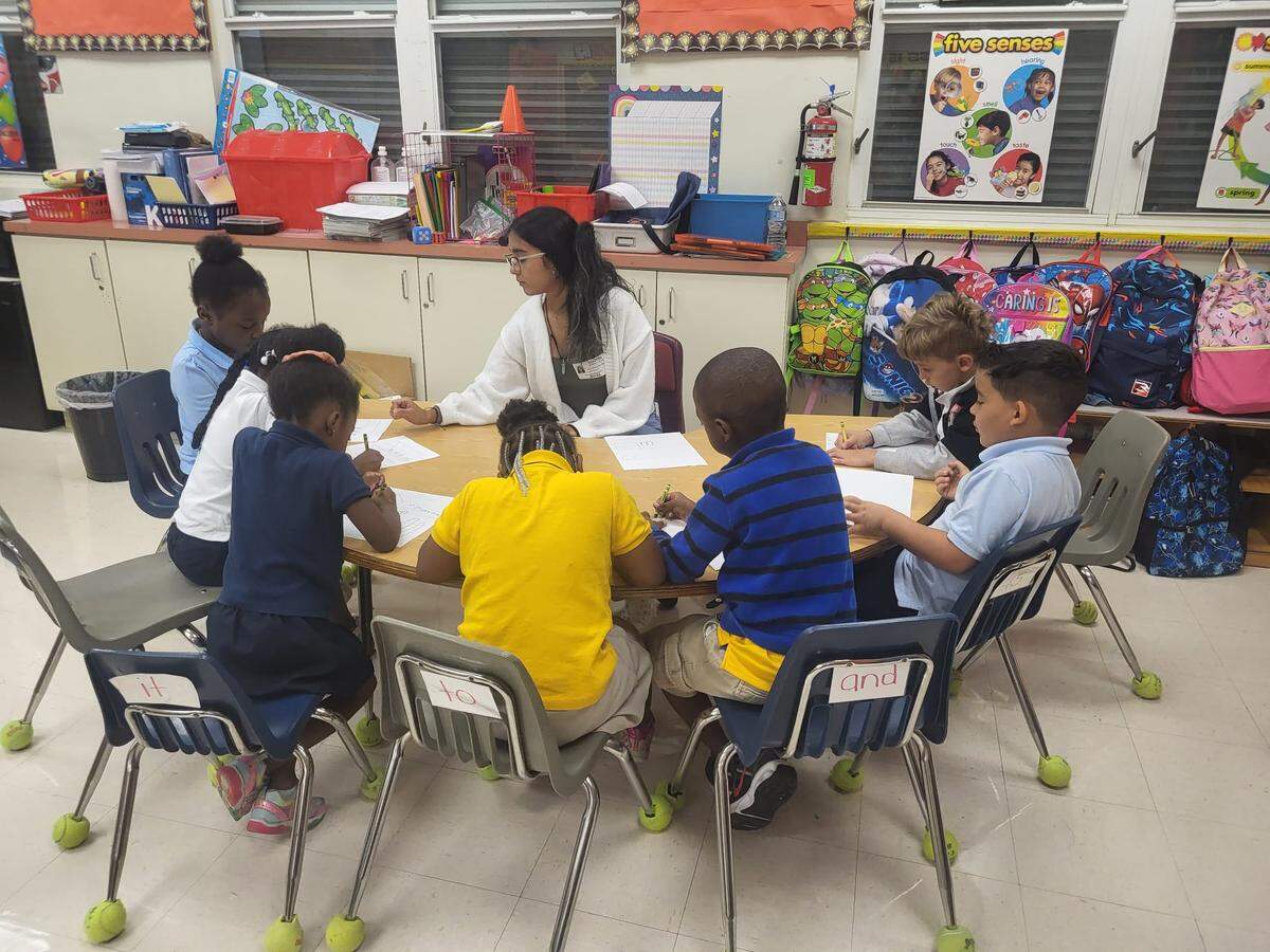 A volunteer from The Lucy Project helping with reading exercises at Norwood Elementary in Miami Gardens.