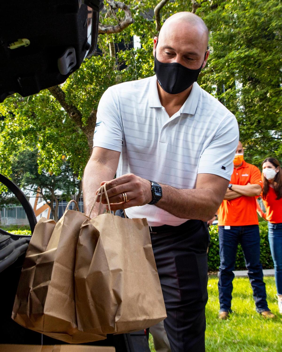 Miami Marlins Chief Executive Officer Derek Jeter helps by filling cars with food during the 12th annual Home Plate Meals Thanksgiving Distribution sponsored by Tito’s Handmade Vodka, in Little Havana, Florida, on Monday, November 23, 2020. Each meal box will contain approximately 40 pounds of food, serving more than 20,000 meals.