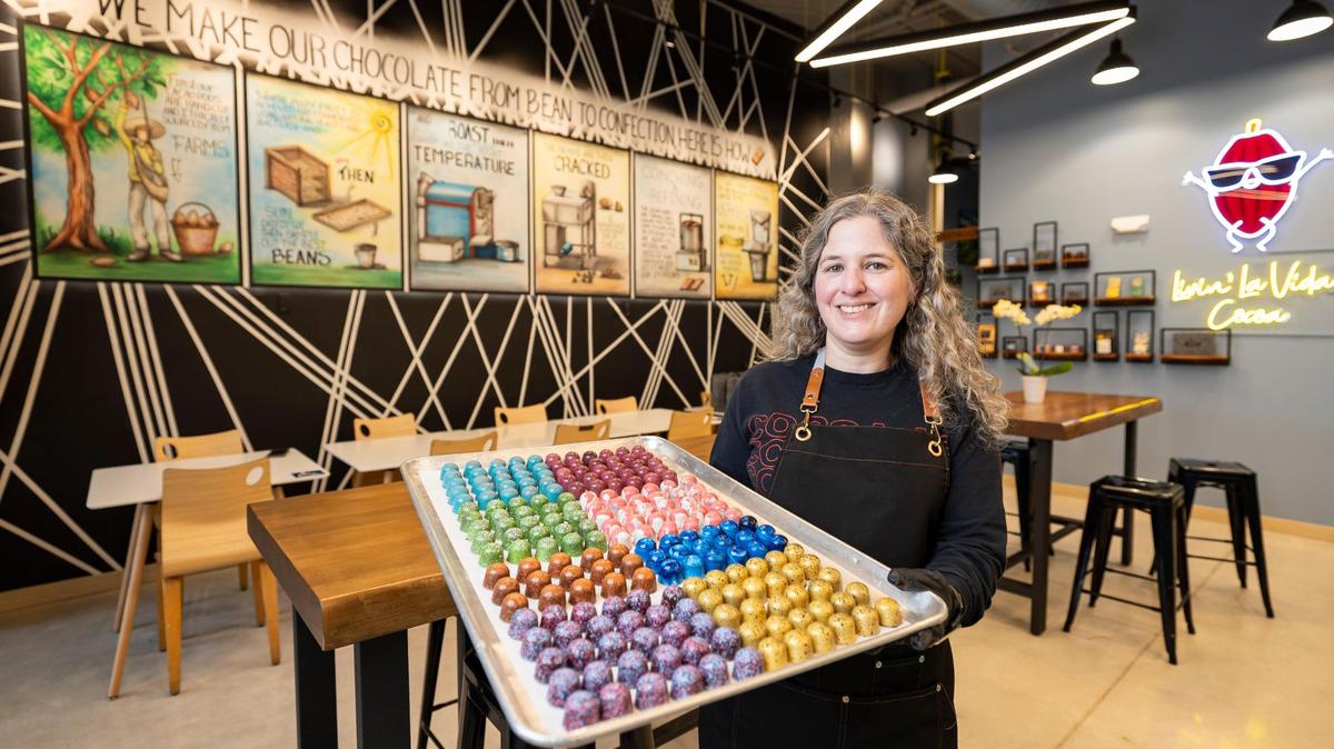 Carolina Quijano, founder of Exquisito Chocolates, holds a tray of assorted bonbons inside her new factory on Calle Ocho.