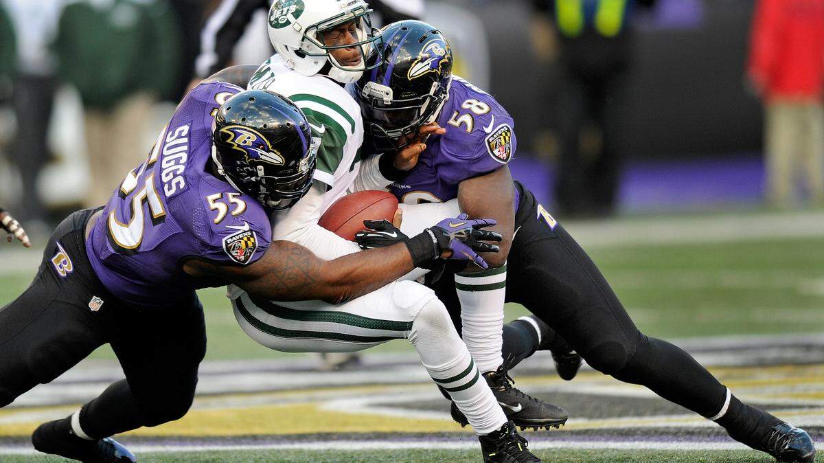 New York Jets quarterback Geno Smith, center, is tackled by Baltimore Ravens outside linebacker Terrell Suggs, left, and outside linebacker Elvis Dumervil, right, during the second half of an NFL football game in Baltimore, Sunday, Nov. 24, 2013.