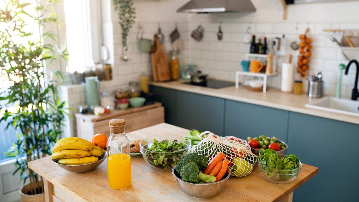 Modern kitchen with fresh fruit and vegetables on the table. 