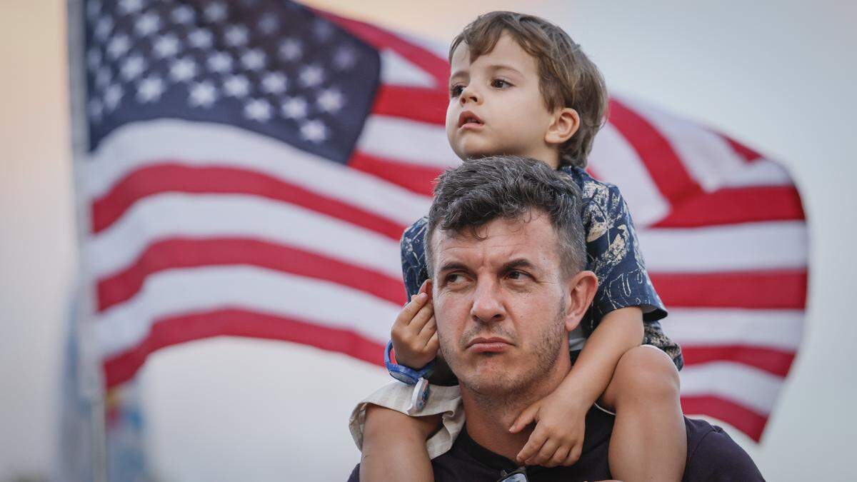 Enrico Helfer, 3, pulls on his fathers ear, Luiz Helfer, as they celebrate during Memorial Day Weekend at the Hyundai Air & Sea Show in Miami Beach, Florida, on Saturday, May 23, 2026.