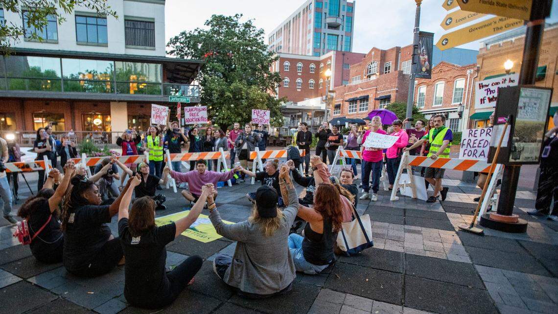 A group of roughly a dozen activists sit in a circle while holding hands with one another, protest SB 300, which would place a ban on abortions after six weeks in Florida, and sing “Lean on Me,” prior to being arrested Monday, April 3, 2023.
