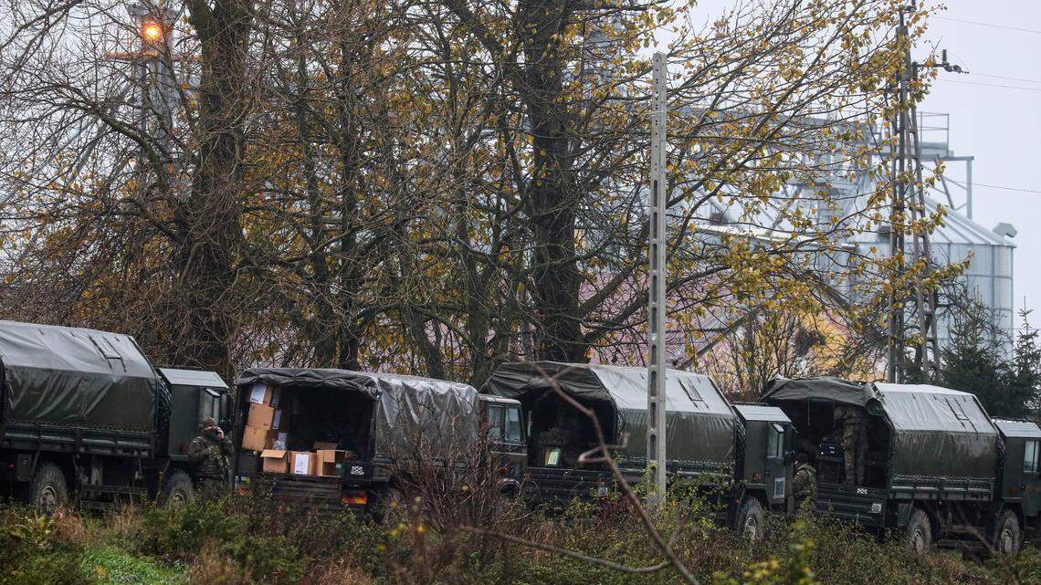 Polish army soldiers unload equipment from their trucks, near the place where a missile struck killing two people in a farmland at the Polish village of Przewodow.