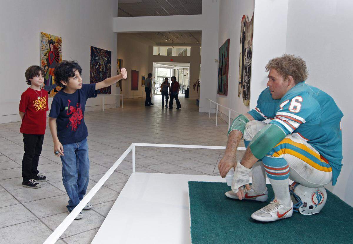 Young visitors at the Lowe Art Museum at the University of Miami check to see whether the “Football Player” is real. The 1981 oil on polyvinyl and mixed media sculpture by artist Duane Hanson was on display in this 2012 photo.