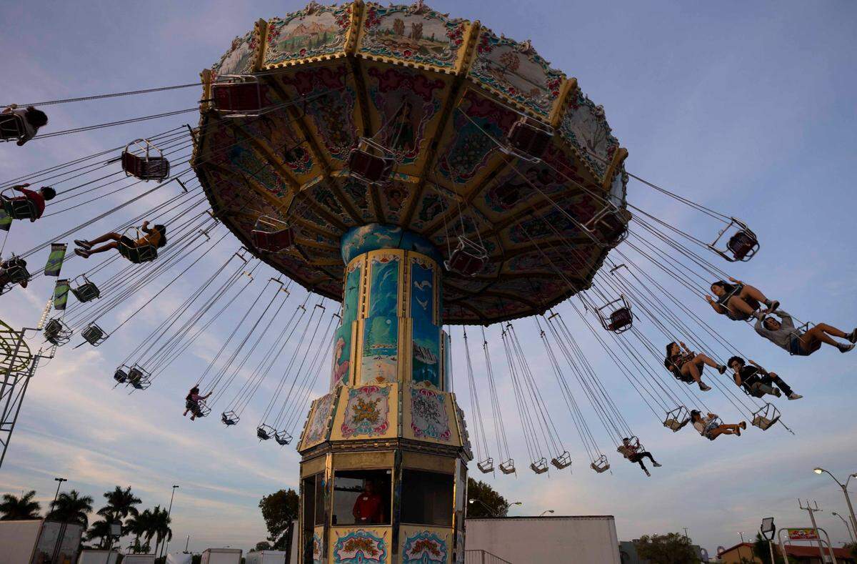 Kids ride the Wave Swinger during the Youth Fair opening day on Thursday, March 14, 2024, at the Miami-Dade Fair and Exposition.