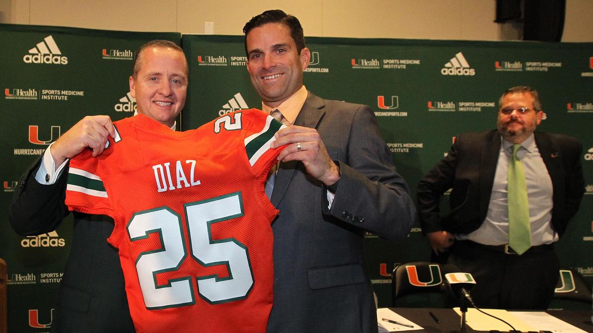 Happier days: Miami Hurricanes athletic director Blake James presents Manny Diaz with a jersey in introducing him as UM’s 25th head football coach at a news conference on at the January 2, 2019. James was dismissed this week, and UM s now searching for a new AD whose first job may be to replace Diaz.