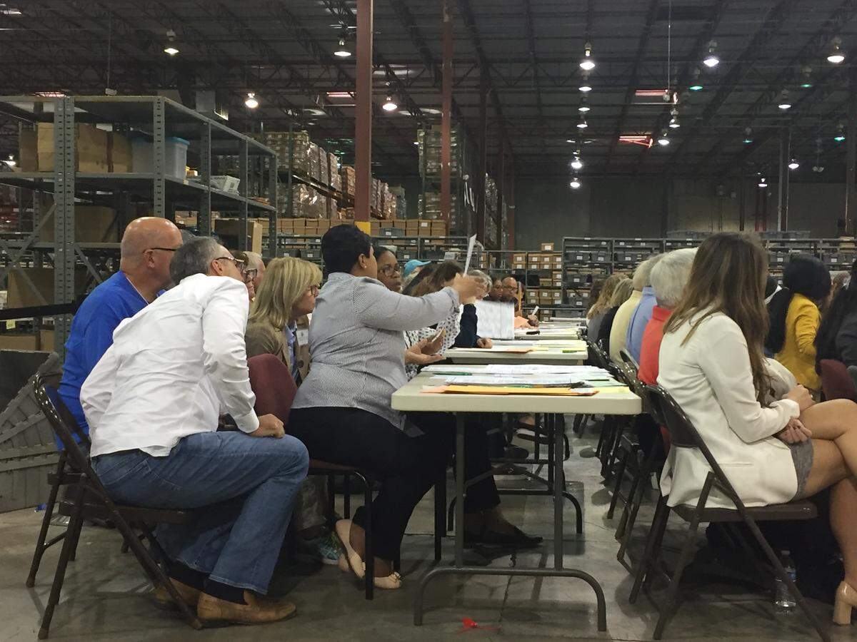 Election workers examine ballots during a hand recount of votes cast in the U.S. Senate race in Palm Beach County on Friday, Nov. 16, 2018. Volunteer observers watch the process.