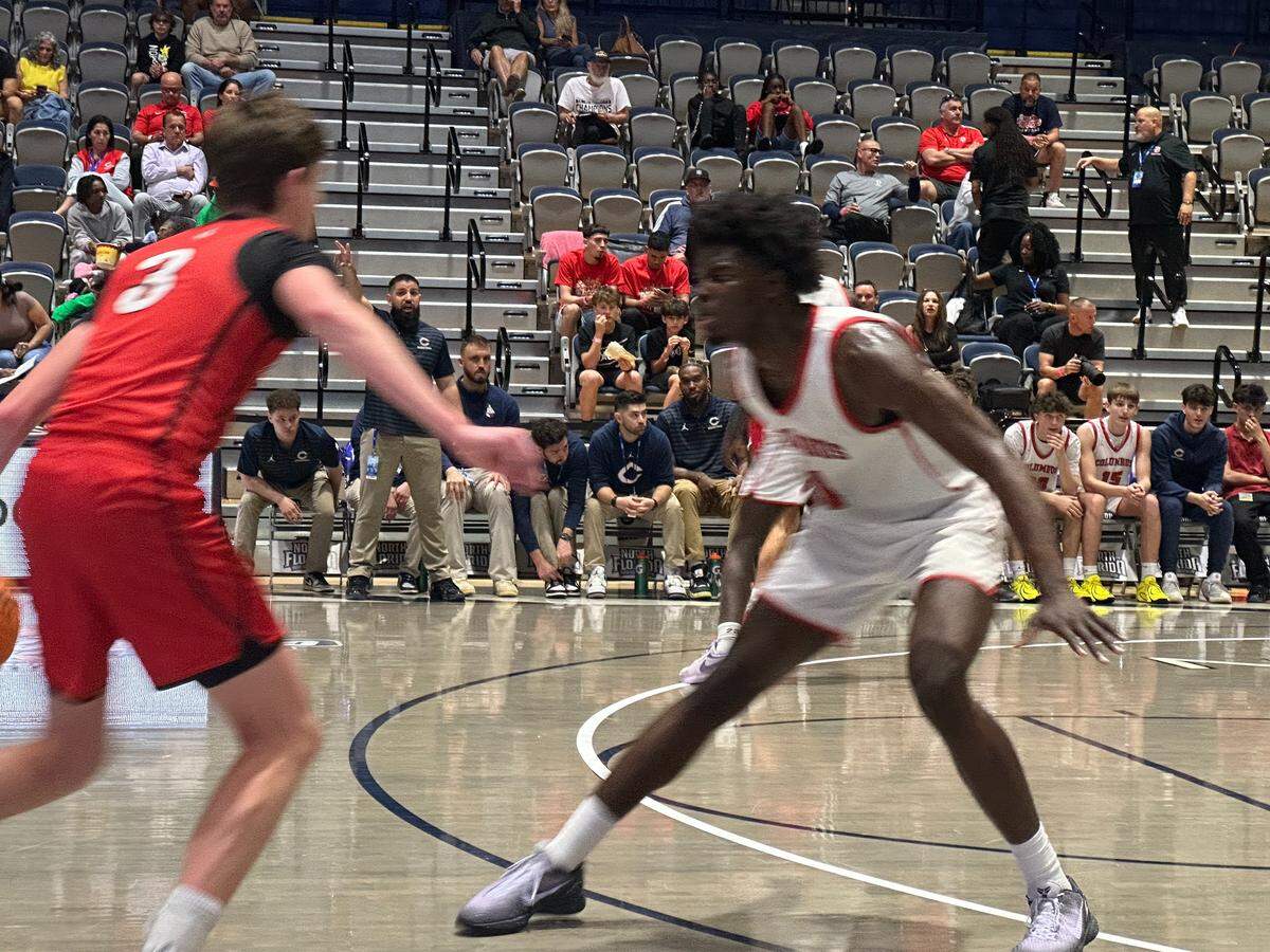 Columbus’ Caleb Gaskins (right) defends Lake Mary guard Tyler Schenck (left) during Friday’s Class 7A state boys’ basketball semifinal at UNF Arena in Jacksonville, Fla.
