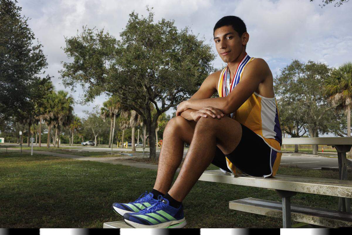 David Lazo, from South Plantation high school and Broward county boys runner of the year, poses with his medals during a Players of the Year photoshoot on Thursday, Dec. 18, 2025, at Brian Piccolo Park in Hollywood, Fla.