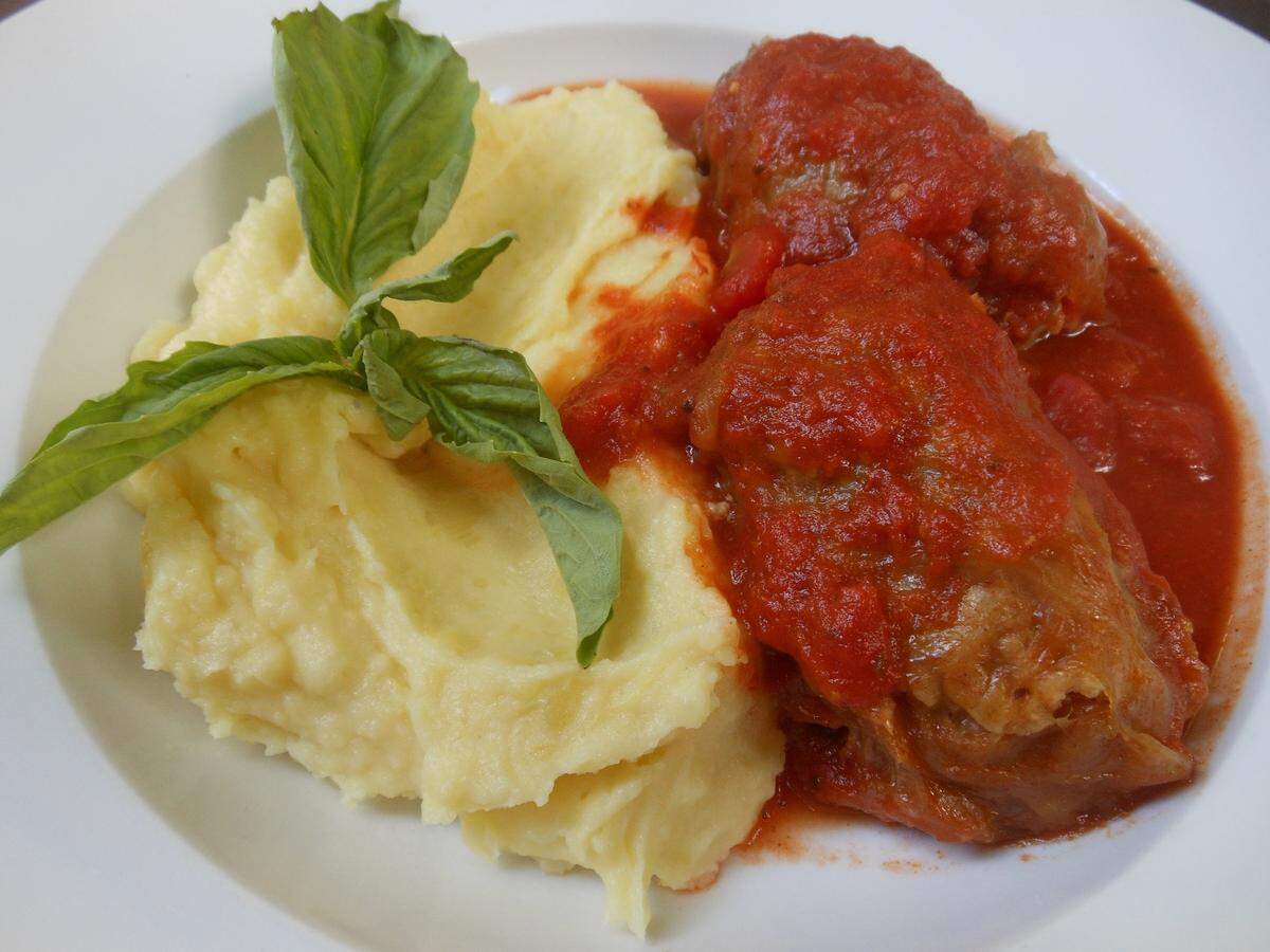 Sarma, beef and rice stuffed cabbage leaves in tomato sauce with mashed potatoes.