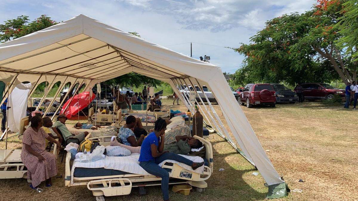 En el hospital OFATMA de Les Cayes, Haití, gestionado por el gobierno, los heridos por el terremoto de magnitud 7.2 del sábado reciben atención bajo una tienda de campaña el lunes. La residencia de los médicos se ha convertido en un quirófano y un autobús escolar sirve de ambulancia para evacuar a los heridos más graves a la capital, Puerto Príncipe.